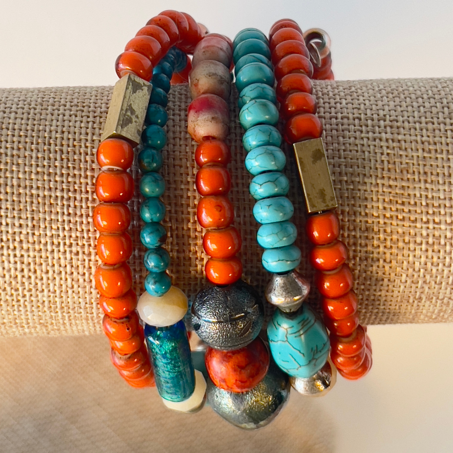 Celebrate the true Native American look with multi-orange coral and turquoise in various shapes, accented with brass and copper metals. Includes splashes of foiled Murano glass from Italy. Silver metal, one size fits all.