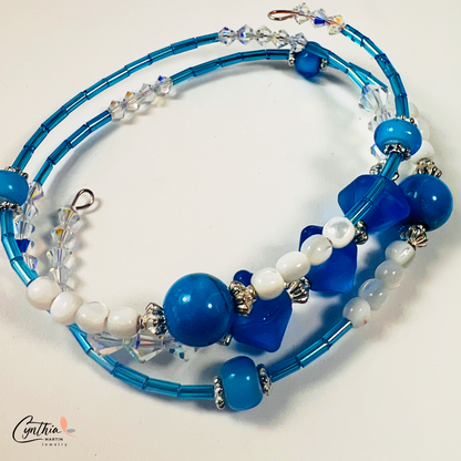 Bracelet featuring blue and iridescent white mother-of-pearl beads with sterling silver accents, delicately hugging 6mm beads.
