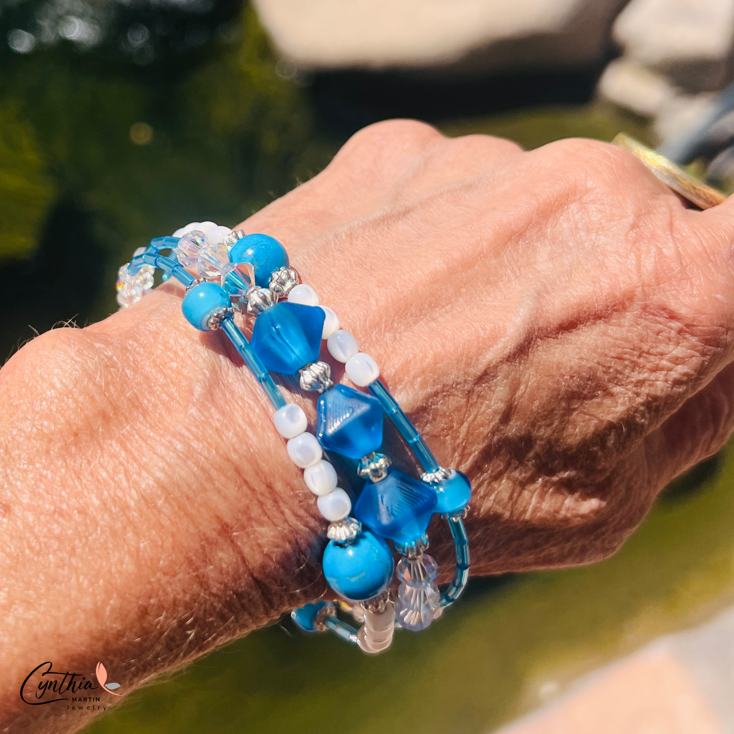 Bracelet featuring blue and iridescent white mother-of-pearl beads with sterling silver accents, delicately hugging 6mm beads.
