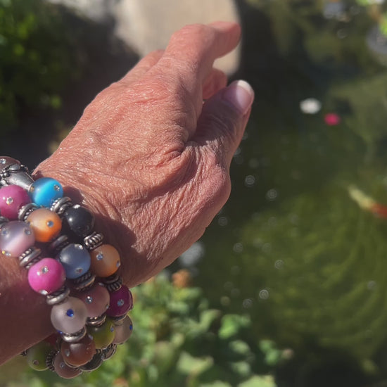 Vibrant 4-layer bracelet featuring festive colors and crystal-covered beads, accented with Bali silver spacers and caps.
