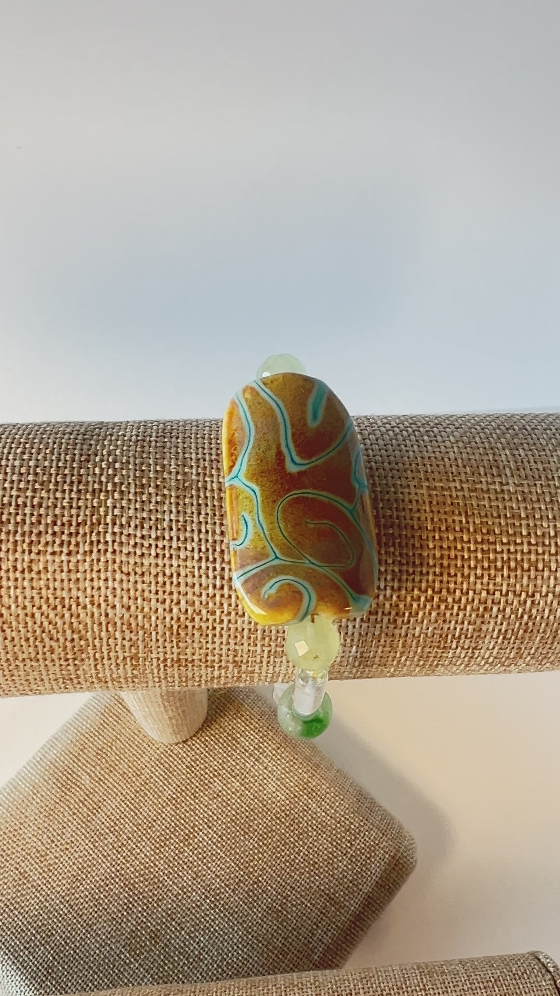 Transparency is the theme here. Quiet, sweet, with green sandstone beads, pale green heart-shaped beads, and beautiful ice green tube beads with splashes of honey-colored rondelles. The focal bead is designed by a dear friend, and I am so glad to be able to show it off to her. Gold metal, wrist size 7 1/2 in.