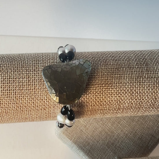 Double-strand gemstone bracelet of black lava rock beads with cultured pearls and mother-of-pearl focal bead, finished with a lobster clasp. Silver metal, wrist size 7 1/2 in.