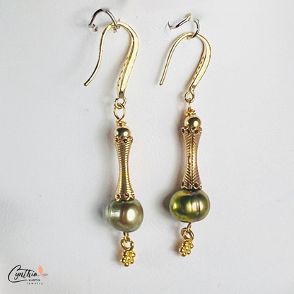 Elegant earrings featuring iridescent green pearls and gold tube spacers, perfect for casual or corporate wear.
