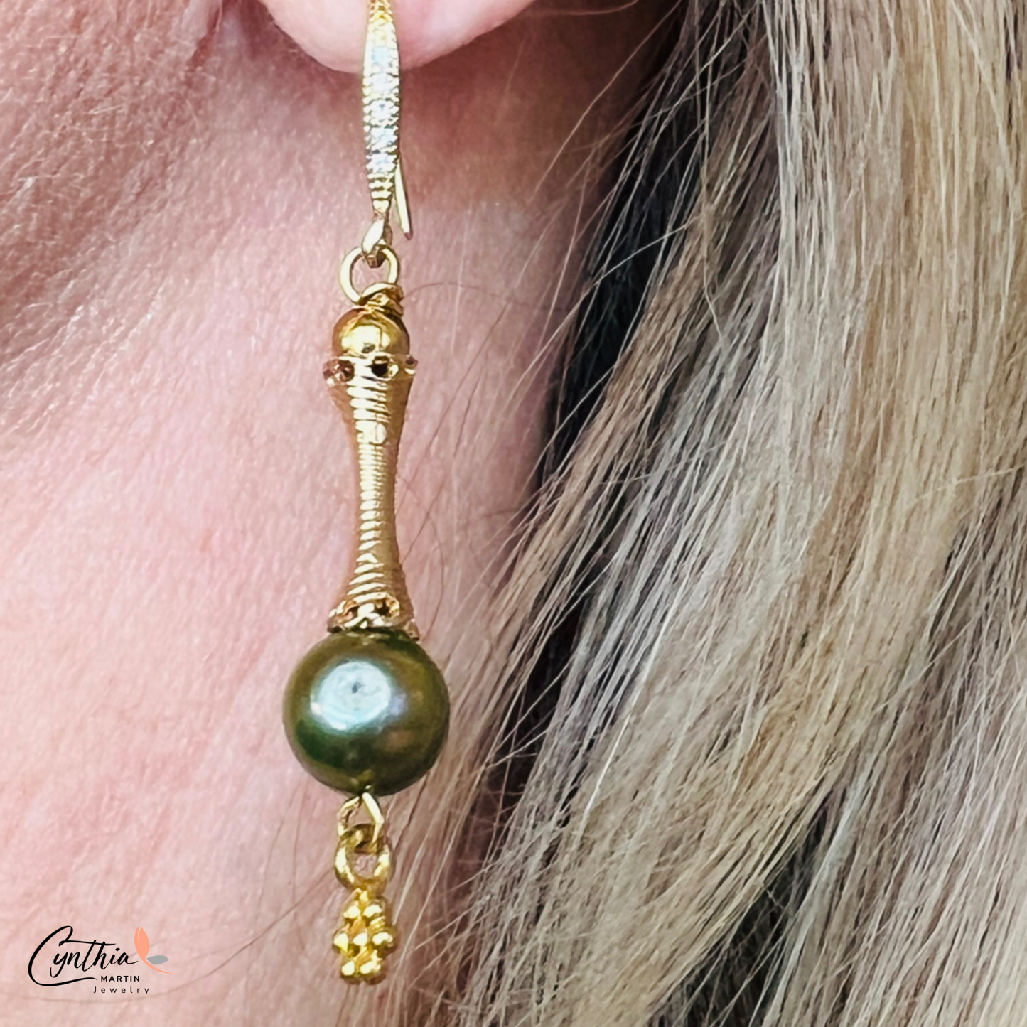 Elegant earrings featuring iridescent green pearls and gold tube spacers, perfect for casual or corporate wear.
