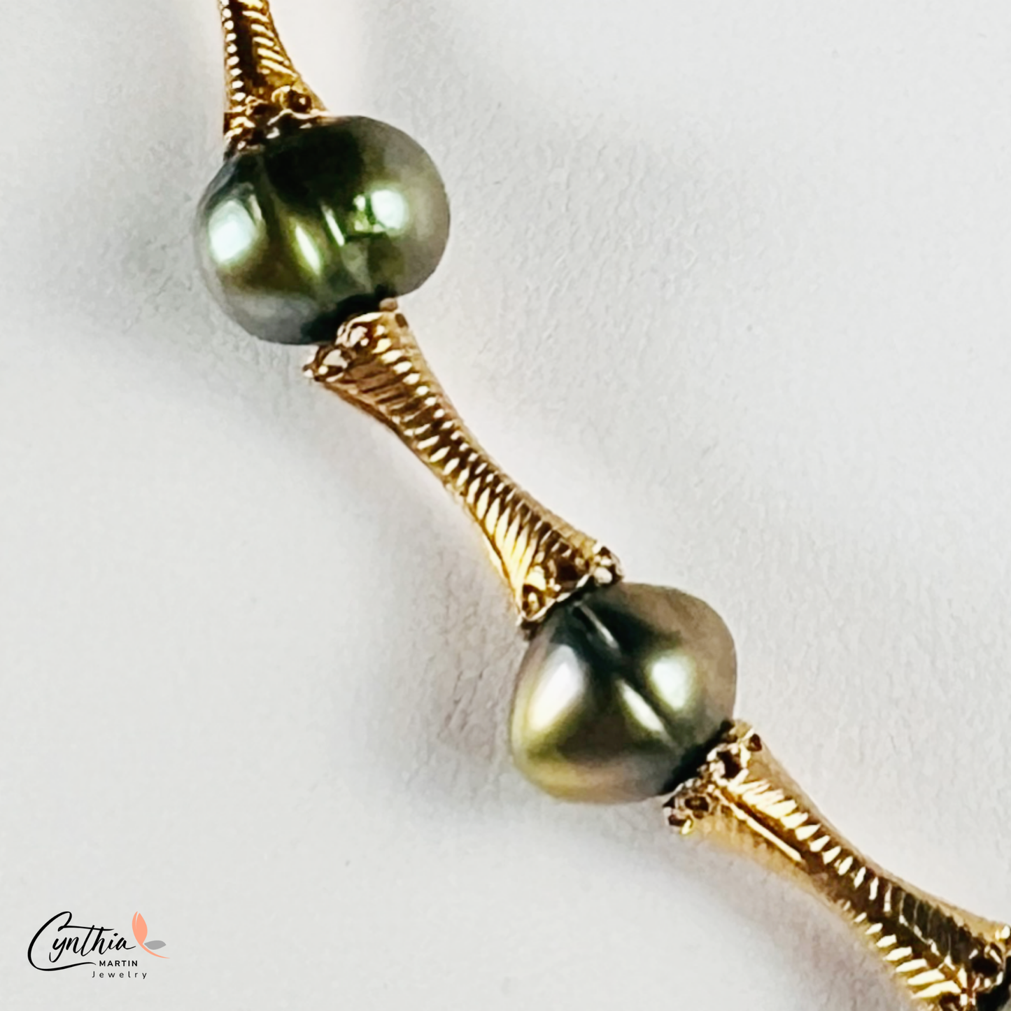 Elegant choker featuring iridescent green pearls and gold tube spacers, perfect for both casual and corporate attire.
